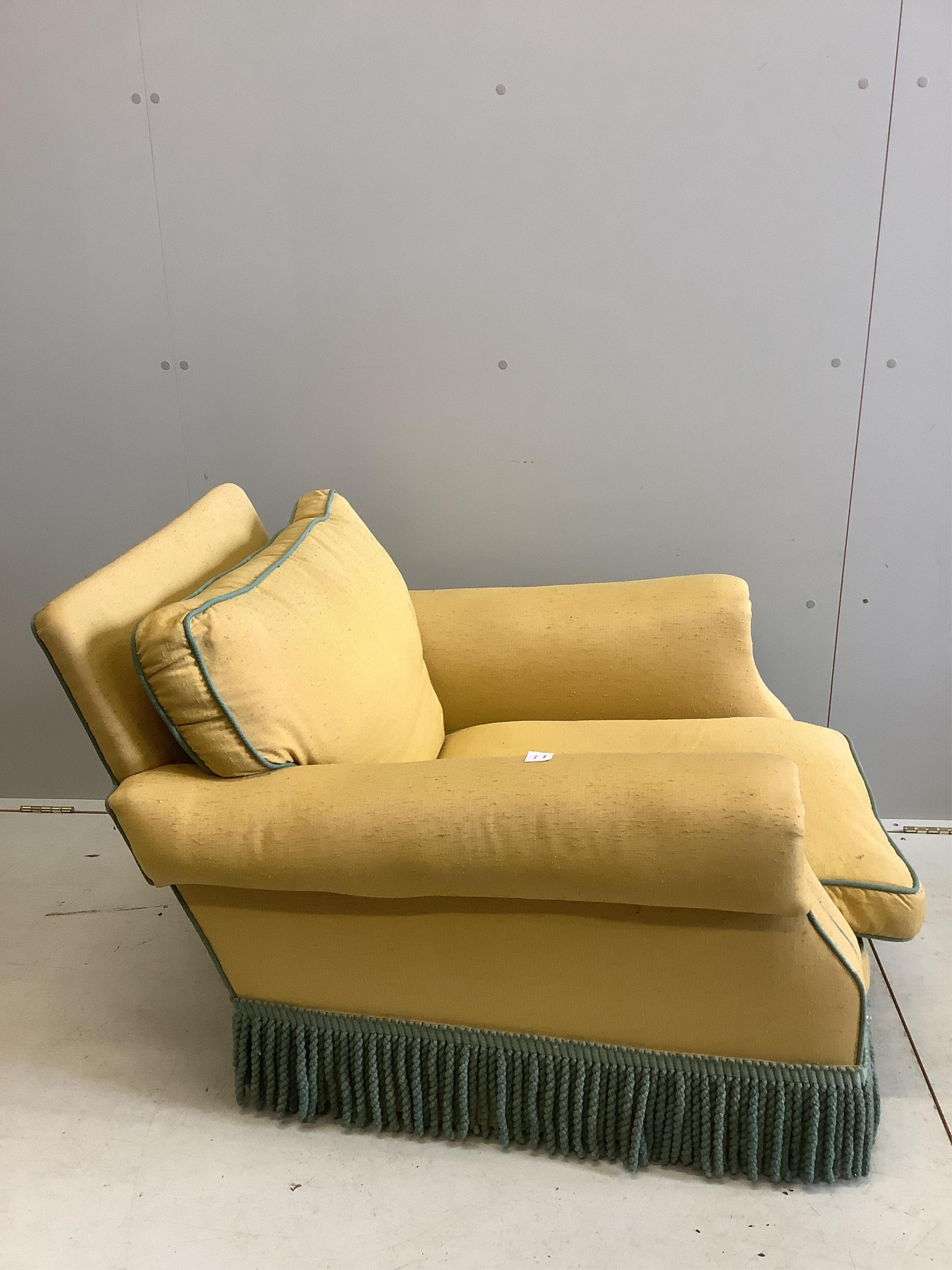 A yellow upholstered Howard style club armchair, width 82cm, depth 90cm, height 70cm. Condition - poor to fair